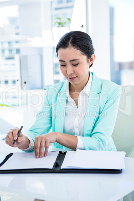 Smiling businesswoman with notes at desk