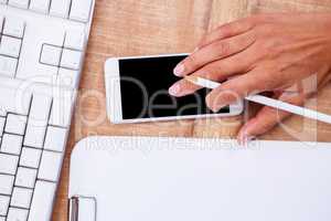 Businesswoman holding pen and smartphone
