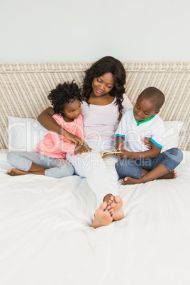 Mother and children reading in bed