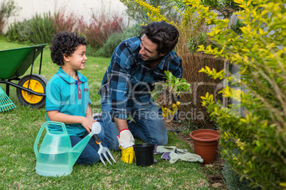 Smiling father and son gardening