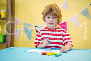 Playful kid colouring in a picture