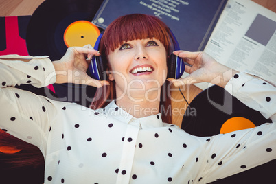 Smiling hipster woman with headphones listening to music