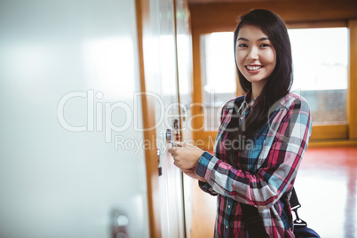 Smiling student opening locker