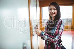 Smiling student opening locker