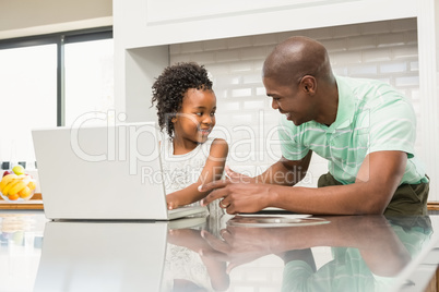 Daughter using laptop with father