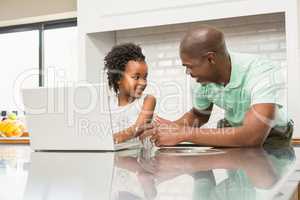 Daughter using laptop with father