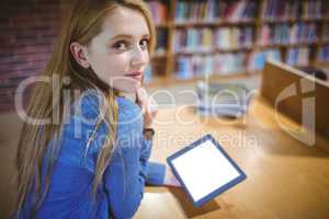 Student using tablet in library looking back at the camera