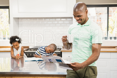 Father with coffee cup reading newspaper