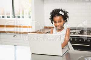 Girl with her laptop at the kitchen table