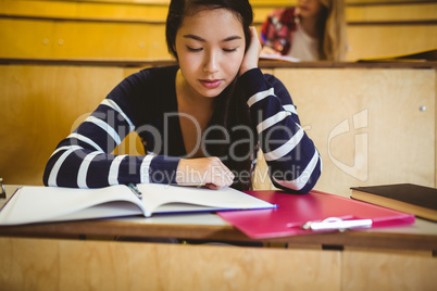 Focused student reading on notebook