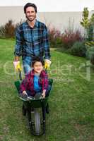 Smiling father with child in the barrow