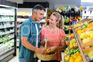 Happy couple putting apple in the basket