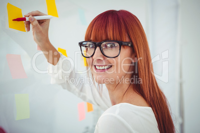 Attractive hipster woman writing on sticky notes