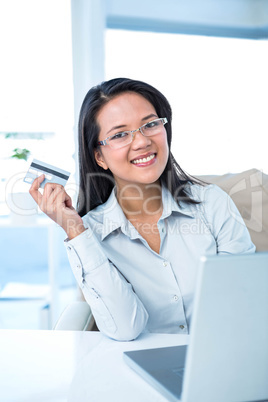 Smiling businesswoman holding credit card