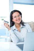 Smiling businesswoman holding credit card