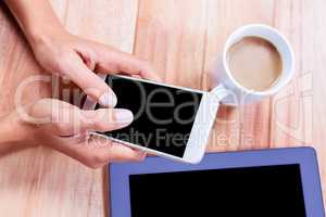 Businesswoman using her smartphone on desk