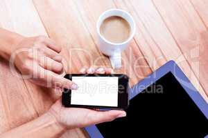 Businesswoman using her smartphone on desk