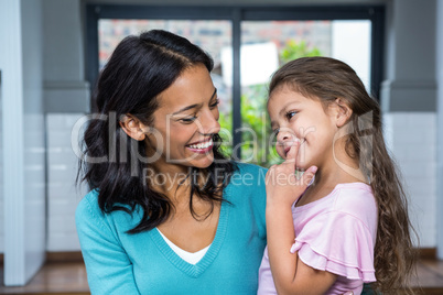 Smiling mother and daughter in living room