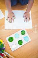 Boy pressing his paint covered hands