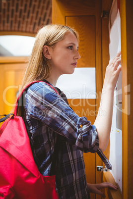 Pretty student looking at notice-board