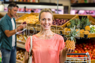 Smiling woman holding a pineapple