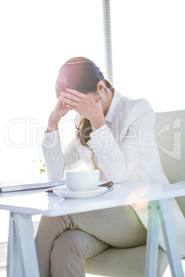 Worried businesswoman holding her head