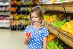 Cute kid looking at an apple