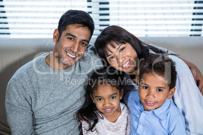 Happy young family posing together on the couch
