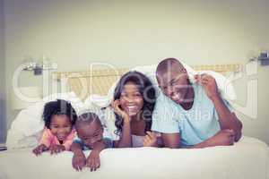 Happy family lying on bed