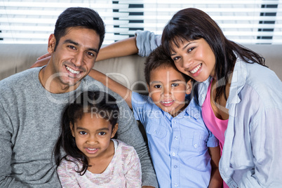 Happy young family posing together on the couch