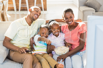 Portrait of a family of four watching tv