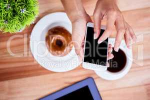 Overhead of feminine hands using smartphone