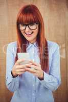 Smiling hipster woman texting on her smartphone