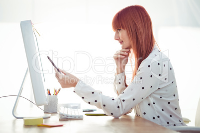 Smiling hipster woman pointing screen with pen