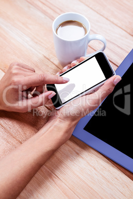 Businesswoman using her smartphone on desk