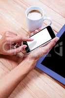 Businesswoman using her smartphone on desk