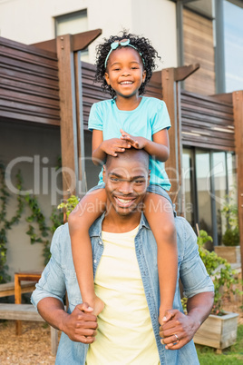 Smiling father giving daughter a piggyback