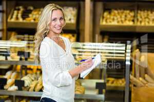 Blonde woman standing and checking list