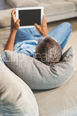 Over shoulder view of casual man using tablet