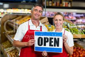 Smiling colleagues holding sign together