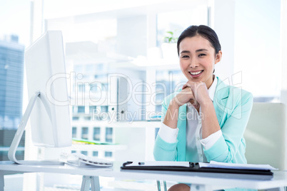 Smiling businesswoman with notes at desk