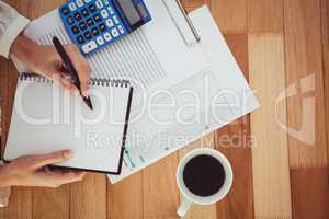 Cropped image of woman writing on notepad