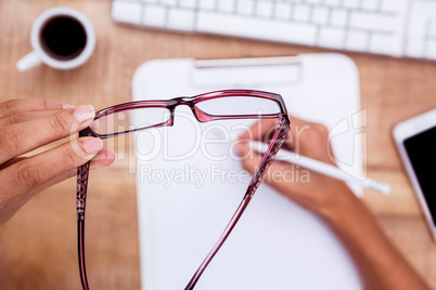 Businesswoman holding eye glasses