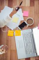 Cropped image of woman with pen using laptop