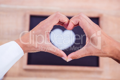 View of hands making heart shape