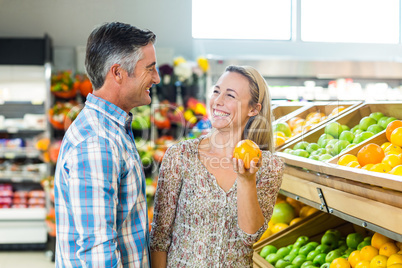 Happy smiling couple picking orange