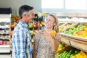 Happy smiling couple picking orange