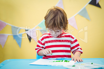 Smiling boy painting a picture