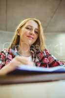 Smiling student taking notes during class