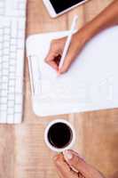 Businesswoman holding coffee cup and pen